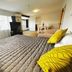Kingswood Manor Motel in Whangarei guest room with bed, sofa, TV and large window