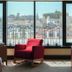Five Seas by Inwood Hotels in Cannes suite with red chair and city view through large windows
