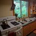 Up The Creek Backpacker's Lodge Roberts Creek kitchen with gas stove, sink, and wood cabinets