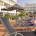 whala!tenerife in Arona: poolside loungers beside a curved outdoor pool and thatched parasols