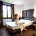 Sweet Hotel in Schiavon guest room with bed, window light, and vase of flowers
