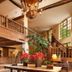 Le Manoir de Gressy lobby with grand staircase, chandelier, mezzanine, and red flowers in Gressy