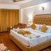 Sun Park Resort, Chandigarh room with king bed, mustard curtains, wood flooring and seating area
