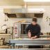Relax Hôtel Beuzeville Honfleur kitchen with chef preparing food in a stainless-steel workspace, Honfleur