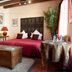 La Demeure Saint-Ours room in Loches with bed, wooden chest, table, and potted plant