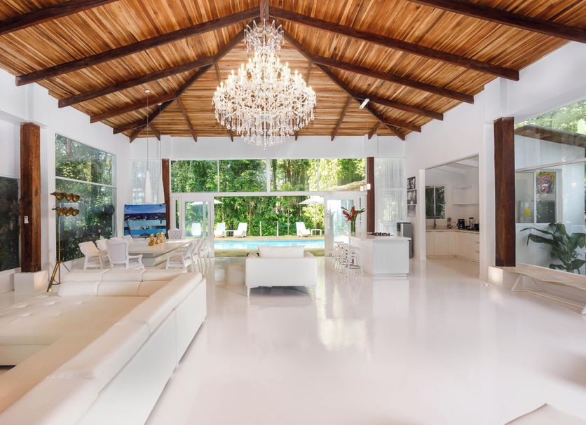 Le Cameleon Boutique Hotel lobby with chandelier, wood ceiling, and pool view in Puerto Viejo de Talamanca