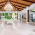 Le Cameleon Boutique Hotel lobby with chandelier, wood ceiling, and pool view in Puerto Viejo de Talamanca