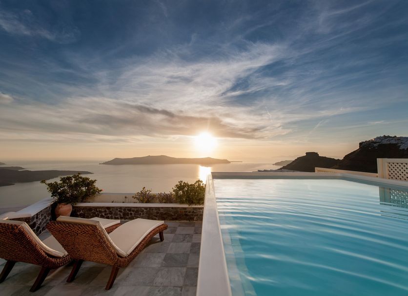 Infinity pool at Vallas Apartments & Villas in Firostefani overlooking the sunset sea and islands