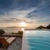 Infinity pool at Vallas Apartments & Villas in Firostefani overlooking the sunset sea and islands