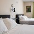 The Marquette Hotel in Madison room with two beds, white bedding, wall art, and green curtains