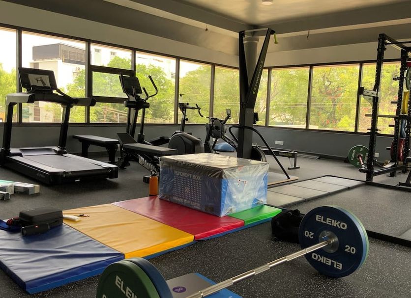 Hotel Rockfort View by Park Elanza gym with treadmills, weights and large windows in Tiruchirappalli