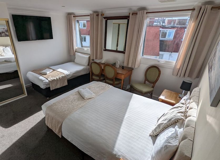 Cecil Court Hotel in Bournemouth guest room with twin beds, wall-mounted TV, desk and windows