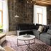 Maison Place Royale by Luxury In Transit in Montreal living room with sectional sofa, rug, and stone walls