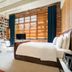 Stamba Hotel in Tbilisi room with bookshelf walls, large window blinds, sofa and bed