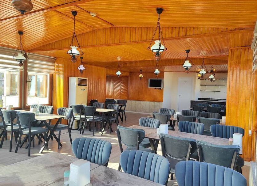 Grand Liza Hotel Istanbul restaurant with wood-paneled ceiling and tables and chairs