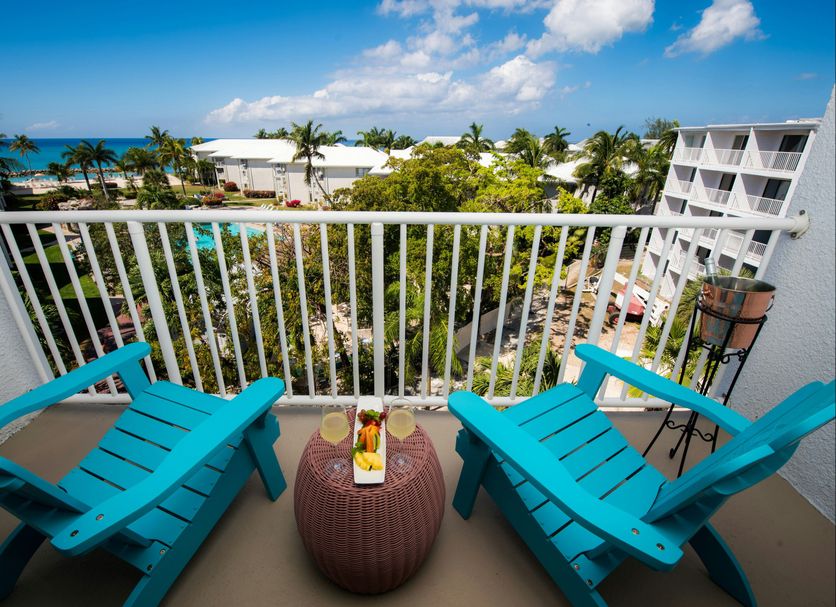 Margaritaville Beach Resort Grand Cayman balcony with turquoise chairs and ocean view in George Town