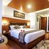 Hotel Shreesu Kathmandu guest room with king bed, wood accents, ceiling lights and bathroom doorway