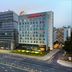 Hampton by Hilton Minsk City Centre hotel exterior in Minsk beside a modern glass tower at dusk
