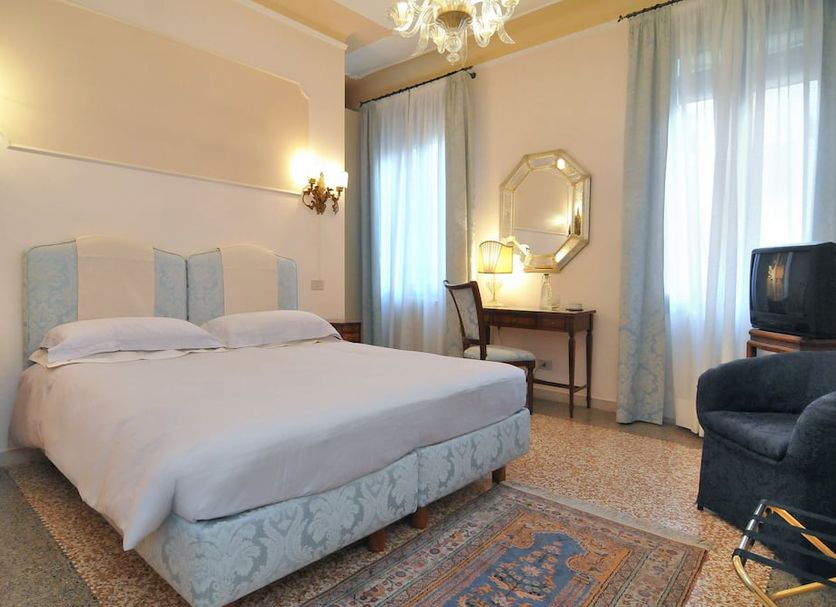 Cà Del Modena room in Venice with double bed, desk, armchair and sheer curtains