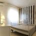 Relais La Pretura, Vieste: bright guest room with striped accent wall, metal bed, desk and chair