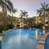 Montpellier Boutique Resort in Noosaville with a palm-lined outdoor pool and balcony views at dusk
