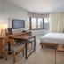 King Room at Wyndham Midtown 45 in New York with city views, desk, and bed by large windows.