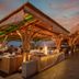 The Nest Hotel Nusa Dua rooftop dining area with bamboo pavilions and sunset sky in South Kuta