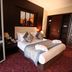 Tolip El Forsan Hotel in Ismailiyah bedroom with king bed, patterned carpet, and bedside lamp