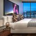 The Rally Hotel at McGregor Square in Denver bedroom with city view through floor-to-ceiling window