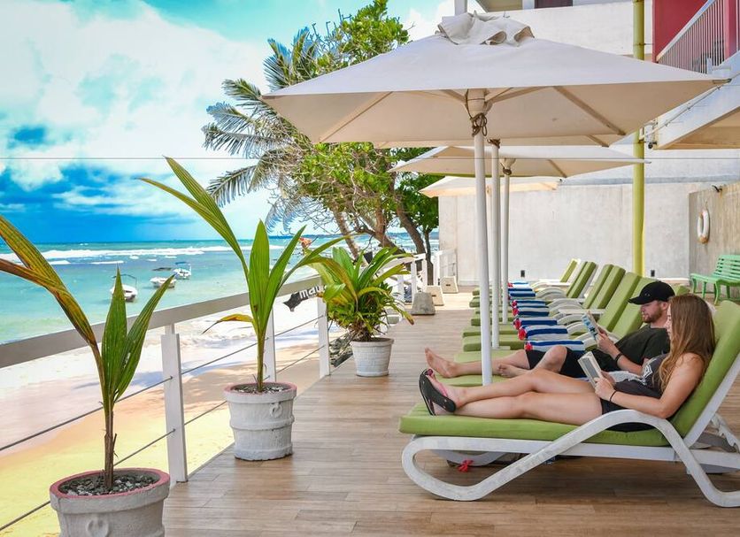 Coral Rock By Bansei in Hikkaduwa: beachfront terrace with loungers, umbrellas and ocean view