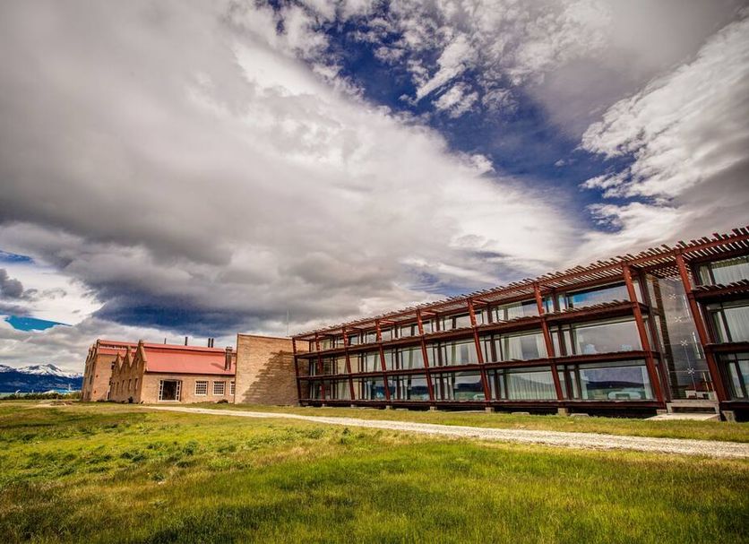 The Singular Patagonia in Puerto Natales with modern glass building and grassy waterfront setting