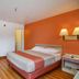 Motel 6 Twentynine Palms guest room with bed, desk, TV, and orange accent wall