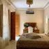 Riad Miral in Marrakech guest room with king bed, dresser, and patterned curtains