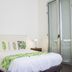 Hotel Casa de la Vega Bogotá bedroom with queen bed, tropical leaf bedding and glass balcony door