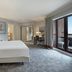 Delta Hotels by Marriott Waltham Abbey guest room with king bed, desk and balcony doors