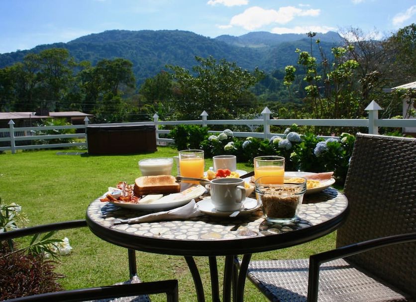 Hotel Central Boquete in Boquete: outdoor breakfast table with mountain views and garden setting