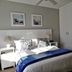 Dolphin Inn Blouberg bedroom in Cape Town with a double bed, bedside tables, and wall art