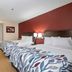Red Roof Inn Raleigh Southwest - Cary room with two beds, desk, and red accent wall in Cary