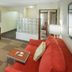Hampton Inn South Haven room with red sofa, TV cabinet, and check-in desk in South Haven