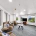 Lakewood Inn & Suites in Dowagiac lobby seating area with TV, windows, and striped carpet