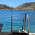 Hotel Melisa in Bozburun with wooden dock ladder leading into clear blue sea and rocky island view