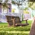 Yellow House B&B in Salado: wooden porch swing under trees beside a colorful cottage lawn