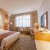 Li An Hotel in Hohhot: bright guest room with king bed, seating area, desk and large window