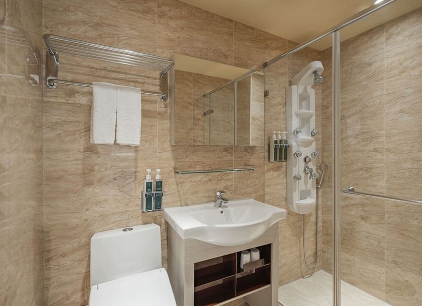 Kindness Hotel - Zhongshan Bade Branch bathroom with shower, sink, towel rack and toilet in Kaohsiung City