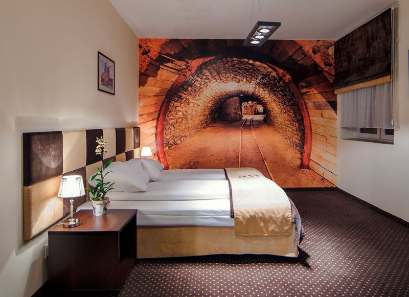 Boutique Hotel's Bytom guest room with double bed and tunnel mural wall in Bytom