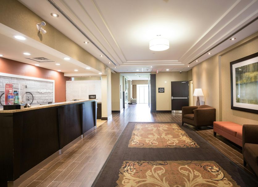 Hampton Inn By Hilton Elliot Lake lobby with front desk, seating area, and hallway to entrance