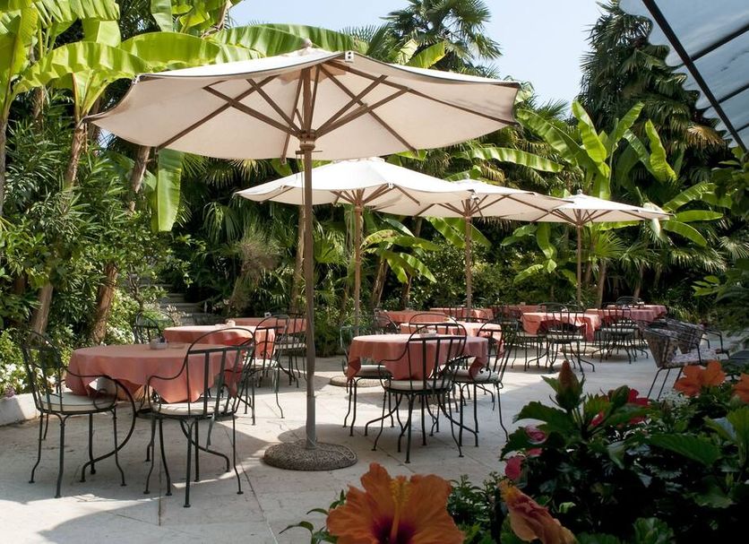 Hotel 4 Stagioni Sensus Spa in Bardolino: tropical terrace with umbrella-shaded tables and chairs