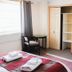 Hotel Rondó in Viña del Mar room with bed, desk, wall TV and red armchair