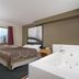 Super 8 by Wyndham Houghton Lake room with spa tub, bed, and window view