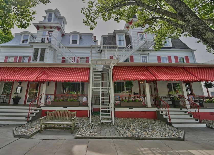 Tom Quick Inn in Milford, historic inn exterior with red awnings, balconies, and central staircase